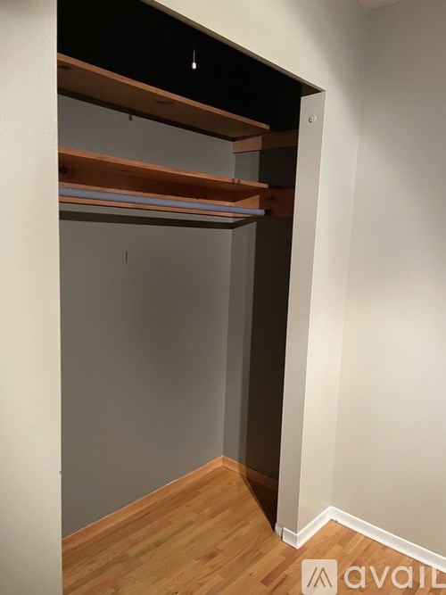 A white wall with a wooden floor and a white door.