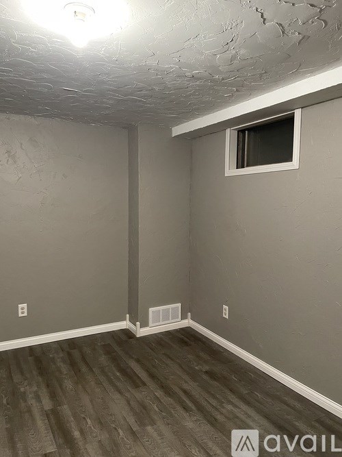 A room with a window and a wall with a crack.