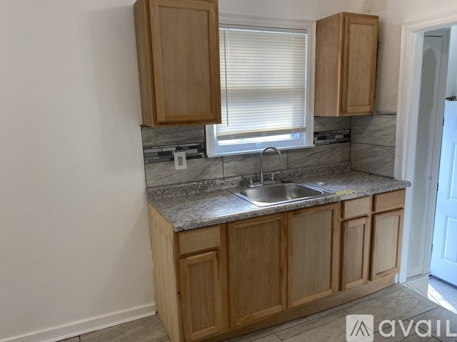 A kitchen with wooden cabinets and a marble countertop.