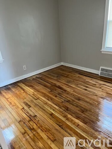 A room with wooden flooring and a window.