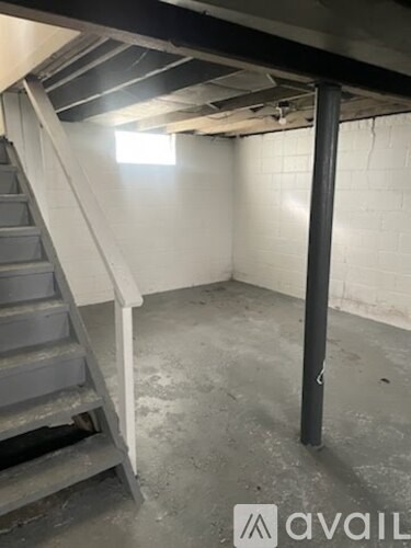 A room with a staircase and a pole.