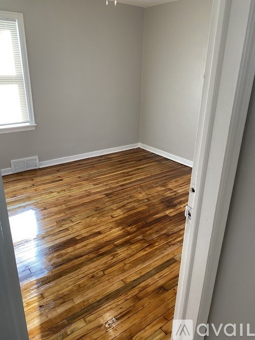 A room with wooden flooring and a window.
