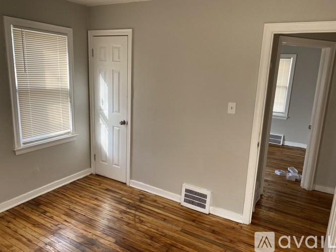 A room with wooden floors and a white door.