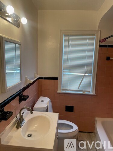 A bathroom with a sink, toilet, and window.