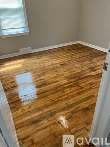 A room with wooden flooring and a window.