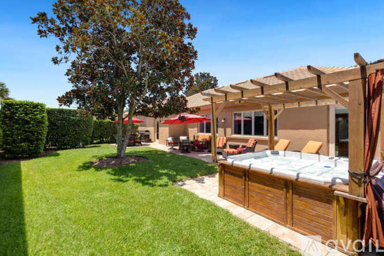 A backyard with a hot tub and a tree.