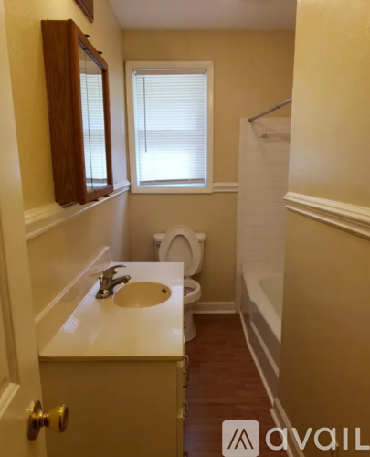 A bathroom with a toilet, sink, and mirror.