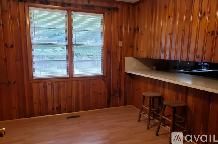 A room with wooden walls and a window with blinds.