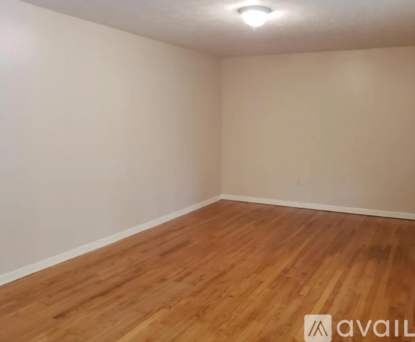 A room with wooden flooring and white walls.