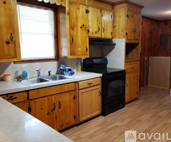 A kitchen with wooden cabinets and a black oven.