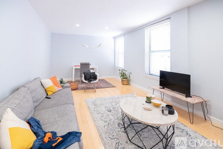 A living room with a grey couch, a coffee table, a television, and a fireplace.
