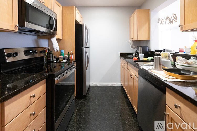A kitchen with black countertops and wooden cabinets.