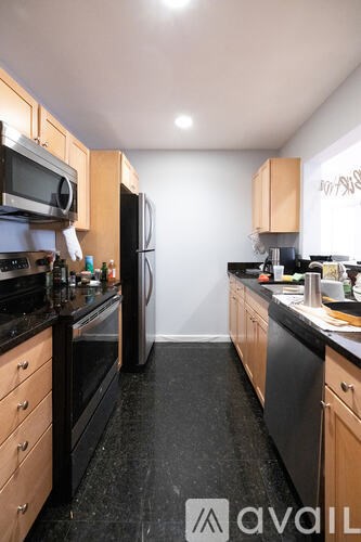 A kitchen with black countertops and wooden cabinets.