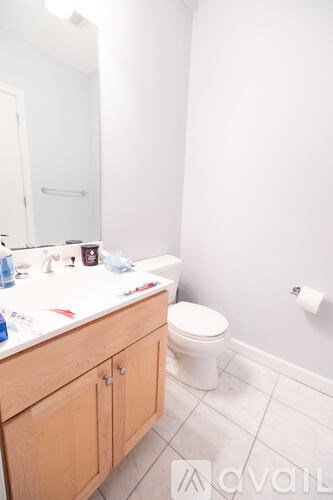 A bathroom with a toilet, sink and mirror.