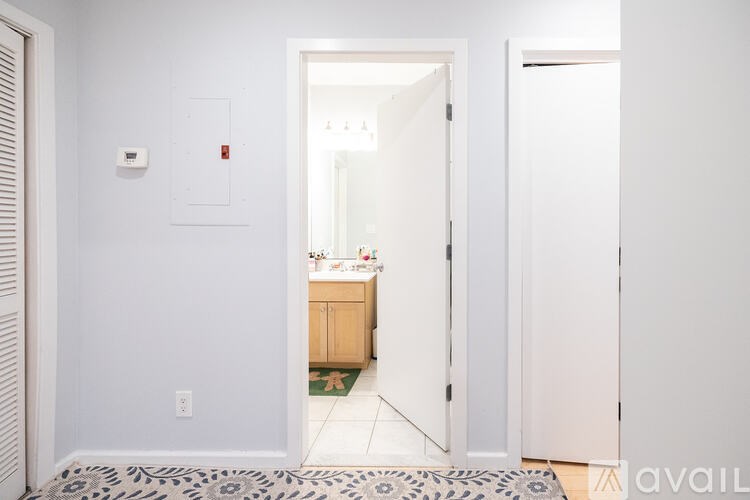 A hallway with a door leading to a kitchen.