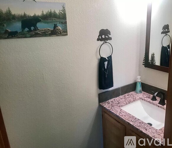 A bathroom with a bear picture on the wall.