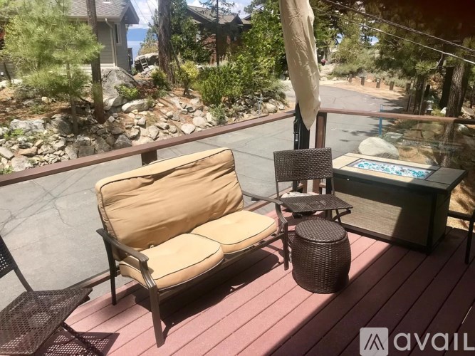 A patio with a couch, table, and umbrella.