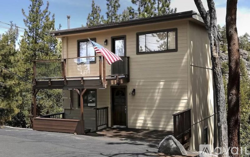 A house with a balcony and an American flag hanging on it.