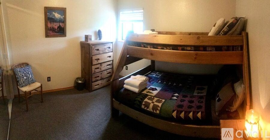A bedroom with a bunk bed and a chair.