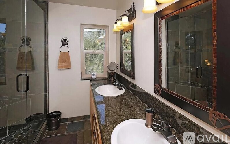 A bathroom with a sink, mirror, and shower.