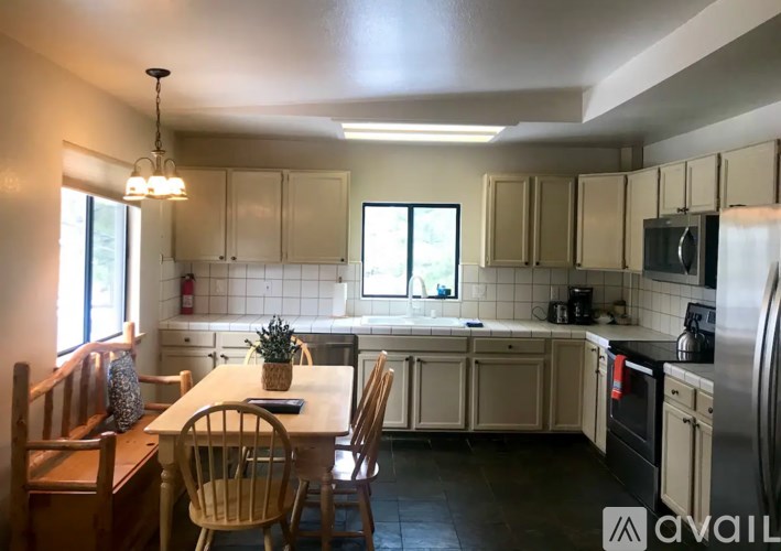 A kitchen with a table and chairs in front of a window.