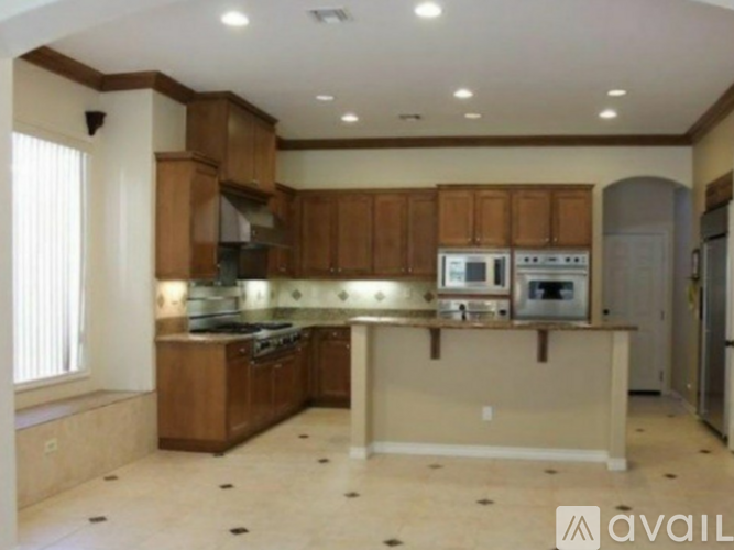 A kitchen with wooden cabinets and a tiled floor.