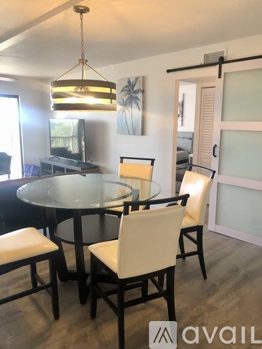 A dining room with a glass table and chairs.