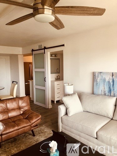 A living room with a brown leather chair and a white couch.