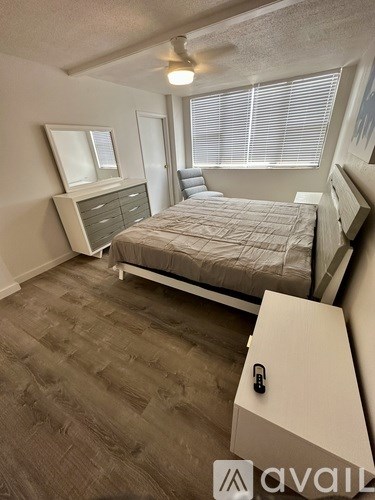 A bedroom with a bed, dresser, and window.