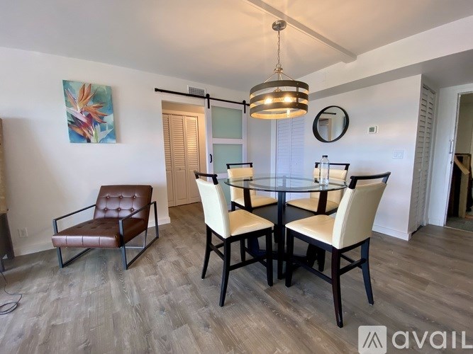 A dining room with a glass table and chairs.