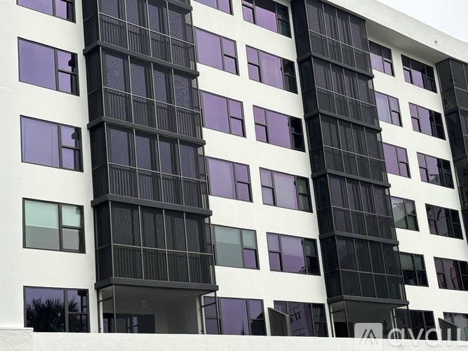 A tall building with black and white balconies.