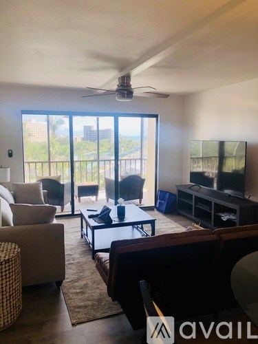 A living room with a flat screen TV and sliding glass doors.