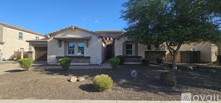 A gate with a decorative design is open to a courtyard with a brick floor.