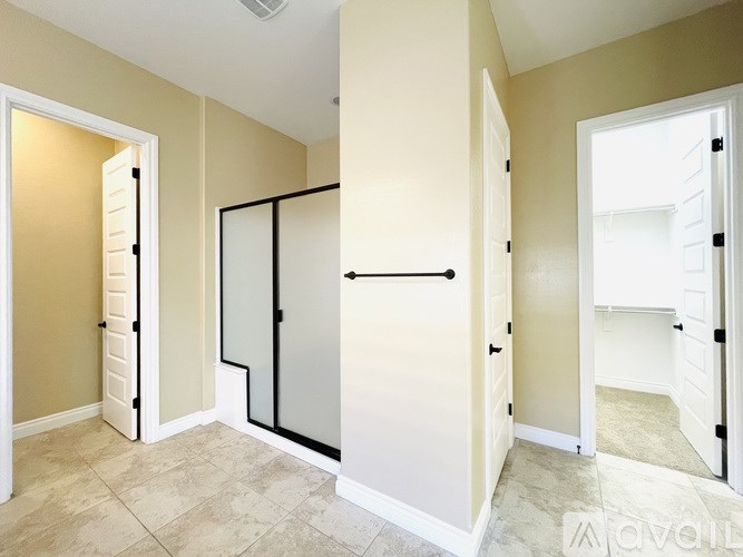 A hallway with a black railing and white doors.