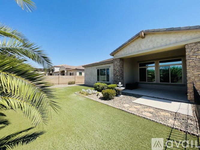 A house with a well-manicured lawn and a palm tree in the foreground.