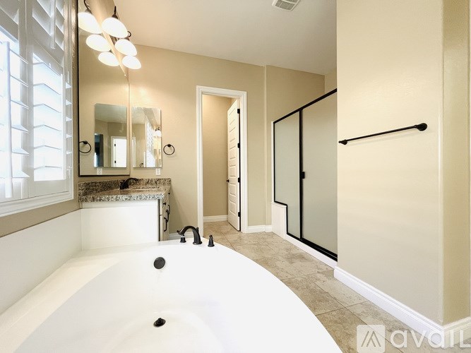 A bathroom with a white tub and a walk-in shower.