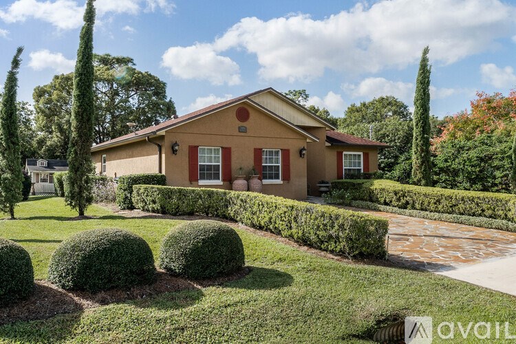 A house with a red roof and a well-manicured lawn.