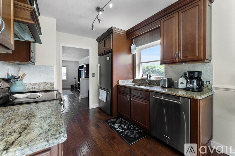 A kitchen with dark wood cabinets and granite countertops.