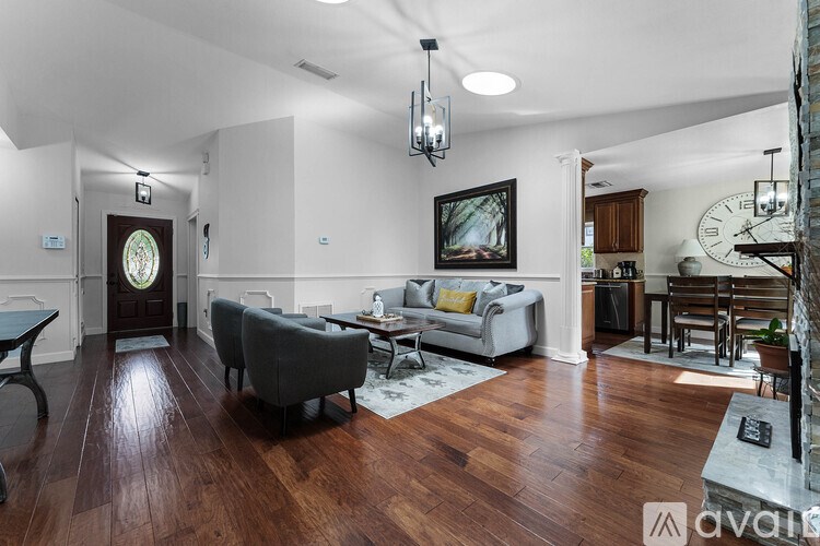 A living room with a grey couch and a wooden floor.