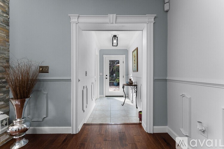 A hallway with a table and a vase on it.