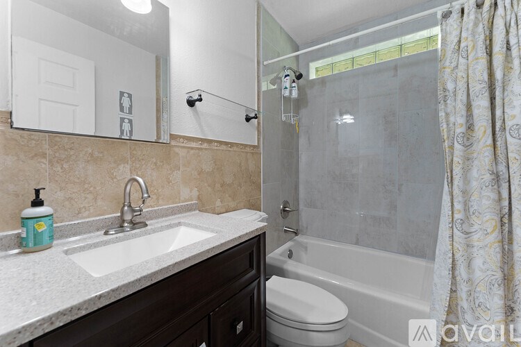 A bathroom with a sink, toilet, and bathtub.