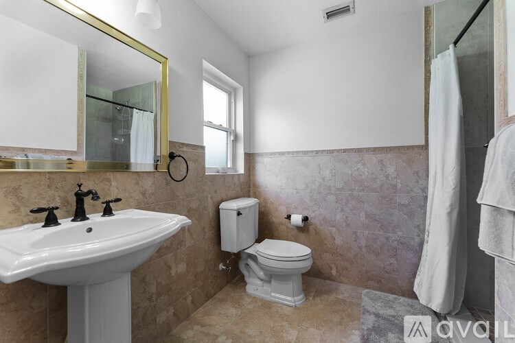 A bathroom with a sink, toilet, and a mirror.
