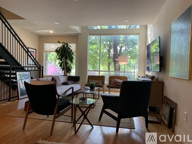 A living room with a black chair and a glass table.