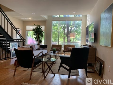 A living room with a black chair and a glass table.