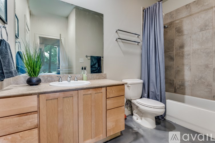 A man is standing in a bathroom with a sink and mirror.