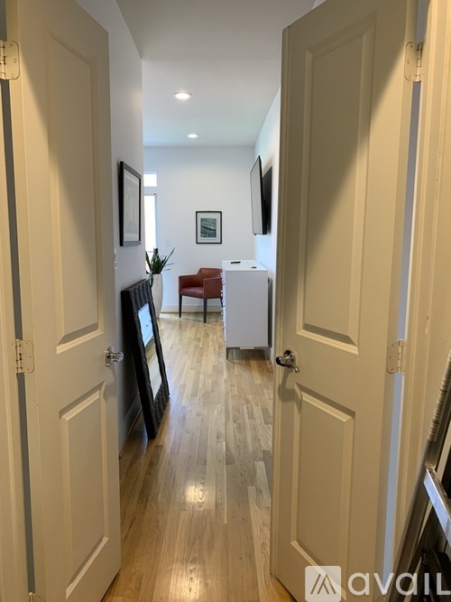 A hallway with a bench and a framed picture on the wall.