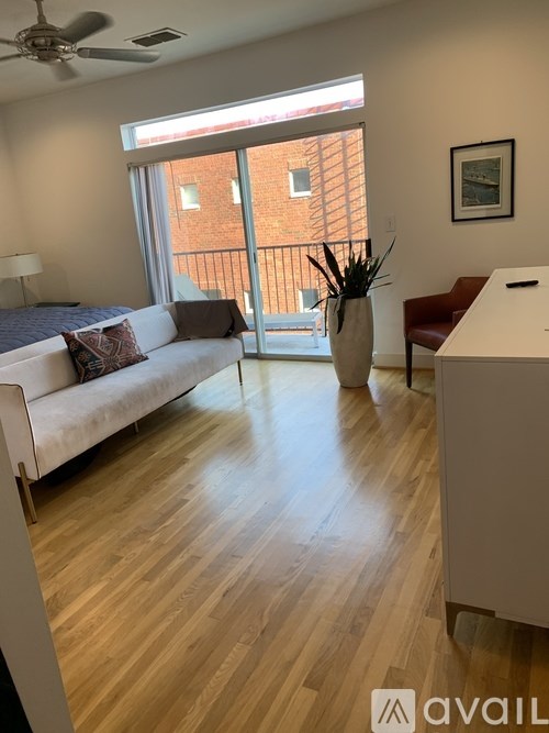 A living room with a white couch and a wooden floor.