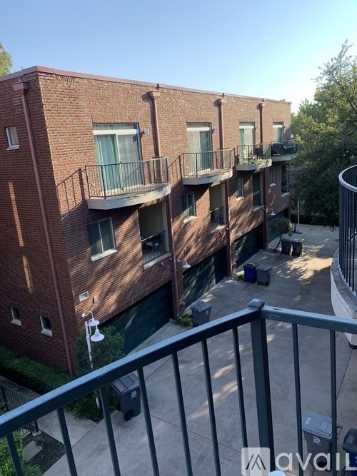 A balcony overlooks a courtyard with a stage and seating area.