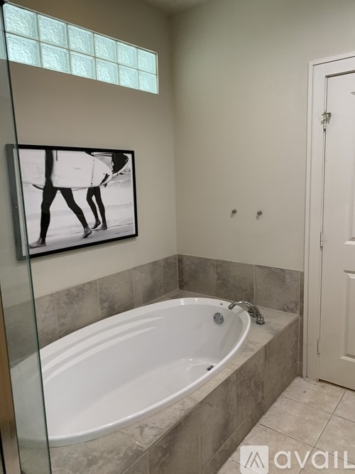 A bathroom with a tub and a picture of a person walking.