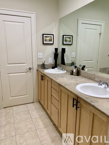 A bathroom with a sink, mirror, and wooden cabinets.